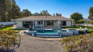 a house with a swimming pool in the yard at Summit Ranch by AvantStay in Temecula