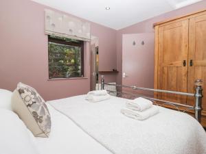 een slaapkamer met een bed met witte handdoeken bij Corner Cottage in Troutbeck