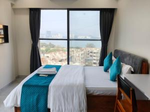 a bedroom with a bed with a large window at Zenith Homes - Premium Suites, near IIT Powai, Hiranandani & Mumbai Airport in Mumbai