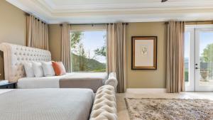 a bedroom with two beds and a large window at Hilltop Estate w Pool Hot Tub Fire Pit Views Cleveland Vista by AvantStay in Murrieta +65 photos