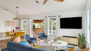 ein Wohnzimmer mit einem blauen Sofa und einem Tisch in der Unterkunft Beach Bungalow 1blck to Beach w Hot Tub Game Room Haven Grove by AvantStay in St. Augustine