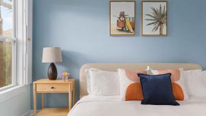 ein Schlafzimmer mit einem Bett mit zwei Bildern an der Wand in der Unterkunft Beach Bungalow 1blck to Beach w Hot Tub Game Room Haven Grove by AvantStay in St. Augustine