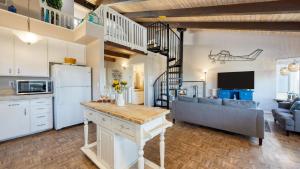 a kitchen and living room with a refrigerator and a couch at Steps to Beach w PatioDeck Foosball Happy Bottom Beach House by AvantStay in Oceano