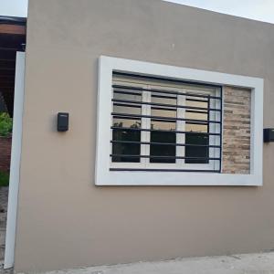 a window on the side of a white building at Terramar cabañas in Mar del Plata +3 photos