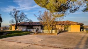 a yellow house with a white fence and a driveway at Private Pool Firepit Wine Room Near Top Paso Wineries Devi Ranch in Paso Robles