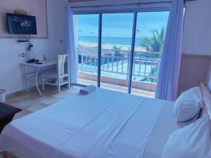 una camera da letto con un letto e vista sull'oceano di Hôtel Amazone a Cotonou