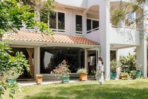 Lakefront Luxury Pool BBQ Mountain Views في كولوم: امرأة تمشي أمام المنزل