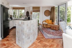 Lakefront Luxury Pool BBQ Mountain Views في كولوم: مطبخ وغرفة معيشة مع جدار من الطوب