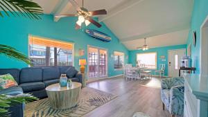 a living room with blue walls and a ceiling fan at Coastal Retreat w Pool BBQ Sunset Views Beers and Sunshine by AvantStay in Port Aransas