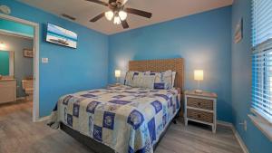 a blue bedroom with a bed and a ceiling fan at Coastal Retreat w Pool BBQ Sunset Views Beers and Sunshine by AvantStay in Port Aransas +39 photos