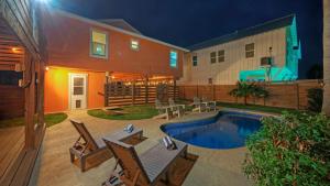 a backyard with a pool and chairs and a house at Coastal Retreat w Pool BBQ Sunset Views Beers and Sunshine by AvantStay in Port Aransas