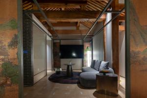 Una sala de estar con un sofá y un televisor. en Hutong Moli Hotel, en Beijing