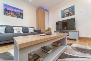 a living room with a couch and a tv at Family Friendly 3BR Townhouse with 6 Beds and Parking in Edinburgh