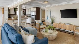 Waterfront Views Shared Dock Short Walk to Beach Shops Surf Edgewater B by AvantStay في شاطئ نيوبورت: غرفة معيشة مع أريكة زرقاء ومطبخ