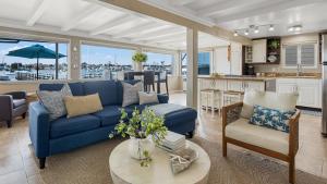 Waterfront Views Shared Dock Short Walk to Beach Shops Surf Edgewater B by AvantStay في شاطئ نيوبورت: غرفة معيشة مع أريكة زرقاء ومطبخ