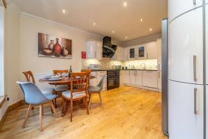 a kitchen with a table and chairs and a refrigerator at Family Friendly 3BR Townhouse with 6 Beds and Parking in Edinburgh