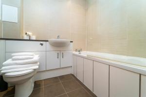 a bathroom with a toilet and a sink and a tub at Family Friendly 3BR Townhouse with 6 Beds and Parking in Edinburgh