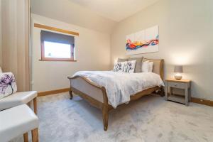 a bedroom with a bed and a chair and a window at Family Friendly 3BR Townhouse with 6 Beds and Parking in Edinburgh