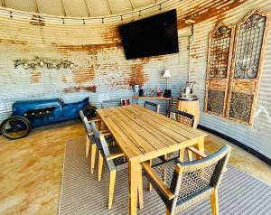 een eetkamer met een houten tafel en stoelen bij Premium Suite 1-Safari Tent-Private Hot Tub in Marble Falls
