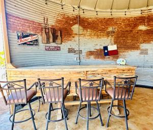 een bar met drie stoelen voor een bar bij Premium Suite 1-Safari Tent-Private Hot Tub in Marble Falls +4 foto's