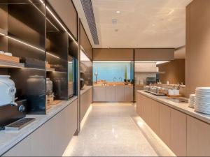 a large kitchen with a long counter in a kitchen at JI Hotel Guangzhou Ximenkou in Guangzhou +30 photos