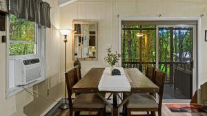 Un comedor con mesa y sillas de madera. en Frolic on Fern by AvantStay Enclosed Deck w Forest Views Bar, en Blakeslee