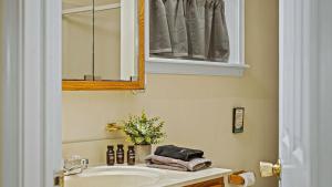 un baño con lavabo y espejo en Frolic on Fern by AvantStay Enclosed Deck w Forest Views Bar, en Blakeslee 33 fotos más