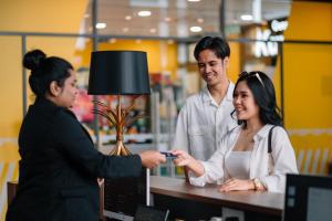 22 Macalisterz George Town By Mana-Mana في جورج تاون: رجل وامرأة يقفان حول طاولة في متجر