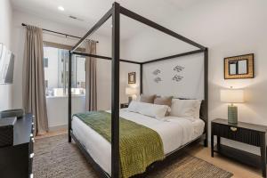 a bedroom with a four poster bed and a television at The Fish Bowl townhouse in St. George