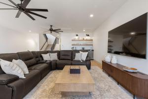 a living room with a brown leather couch and a table at The Fish Bowl townhouse in St. George