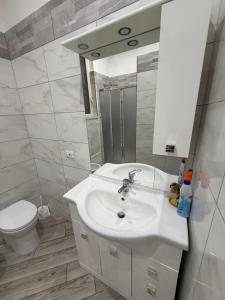 a bathroom with a sink and a toilet and a mirror at Metro Stay piscinola in Naples