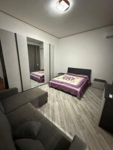 a room with a bed and a couch and a mirror at Metro Stay piscinola in Naples
