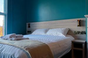 a bedroom with a bed with a blue wall at McCloskeys Residences in Dublin +8 photos