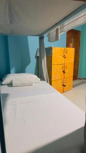 Una cama blanca en una habitación con armarios amarillos. en Mabybaby hostel, en Unawatuna 15 fotos más