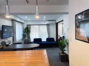 东京Plan A Tennozu Isle的客厅里有一张蓝色的沙发和一张桌子