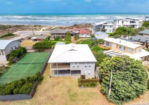 an aerial view of a house with a tennis court at The Summer Residence Middleton in Middleton