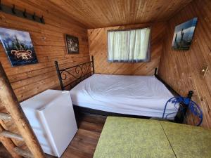 una camera da letto con un letto in una cabina di legno di Oyama Lake Lodge a Lake Country