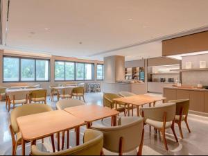 a restaurant with tables and chairs and a kitchen at JI Hotel Guangzhou Ximenkou in Guangzhou
