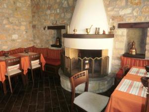 a restaurant with a fireplace and tables and chairs at Hagiati Guesthouse in Ioannina