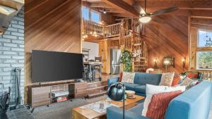 a living room with a blue couch and a flat screen tv at Scenic North Shore Stay w Games Near Snow Summit Lakeview Lodge by AvantStay in Fawnskin