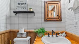 a bathroom with a sink and a toilet and a mirror at Scenic North Shore Stay w Games Near Snow Summit Lakeview Lodge by AvantStay in Fawnskin +32 photos