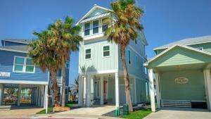 a blue house with palm trees in front of it at La Concha Blvd 31 - in Padre Island