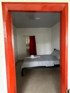 a bedroom with a bed with a red frame at Finca hotel VillaLuna in Mesetas