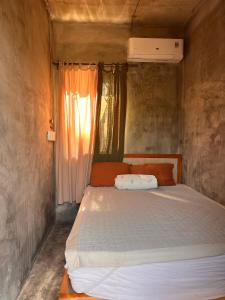 a bed in a small room with a window at Mơ House Eco Homestay on hill in Phú Quốc
