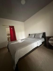 a bedroom with a large bed with a red curtain at Finca hotel VillaLuna in Mesetas