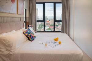 22 Macalisterz George Town By Mana-Mana في جورج تاون: سرير أبيض عليه فاكهة مع نافذة +44 صورة