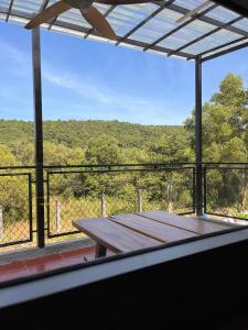 a picnic table on a balcony with a view of the forest at Mơ House Eco Homestay on hill in Phú Quốc