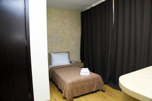 1 dormitorio con cama y cortina negra en Iveria Hotel, en Khashuri 7 fotos más