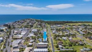 an aerial view of a parking lot next to the ocean at The Cheeky Palm - Beachy, enjoy a cheeky cocktail! in Woolgoolga