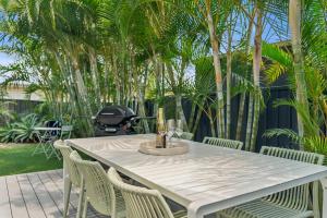a white table with chairs and a grill at The Cheeky Palm - Beachy, enjoy a cheeky cocktail! in Woolgoolga